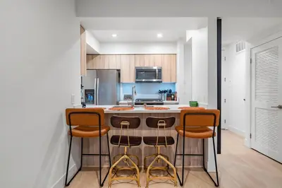 a kitchen with a bar with three stools at 15 City View Santa Monica in Los Angeles