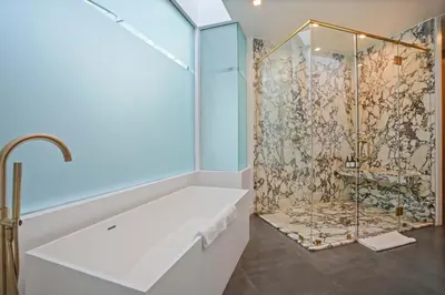 a bathroom with a shower with a white tub at The Elvis Villa by Stay Awhile Villas in Los Angeles