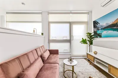 a living room with a couch and large windows at Amazing studio in SM Promenade! Free parking! in Los Angeles