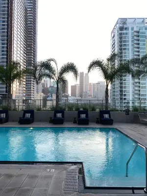 a large swimming pool with palm trees and buildings at Elegant Luxury 1 Bedroom studio in Downtown LA in Vernon