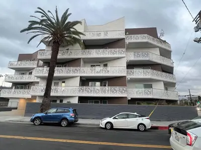 two cars parked in front of a building with a palm tree at Silver Lake Stylish Penthouse One Bdrm with Parking included in Los Angeles