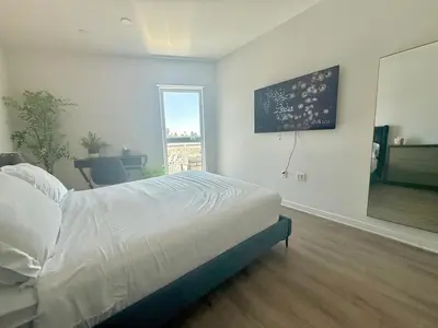 a bedroom with a bed and a large window at Silver Lake Stylish Penthouse One Bdrm with Parking included in Los Angeles