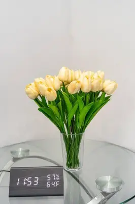 a vase filled with yellow flowers on a glass table at Adorable 2BR-2BA House with EV & Free Parking and Family Friendly in Los Angeles in Los Angeles