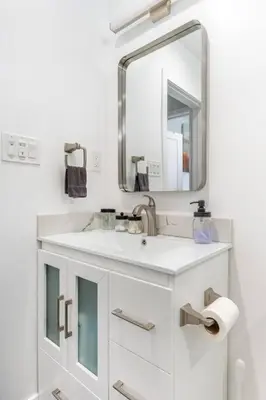 a white bathroom with a sink and a mirror at Adorable 2BR-2BA House with EV & Free Parking and Family Friendly in Los Angeles in Los Angeles