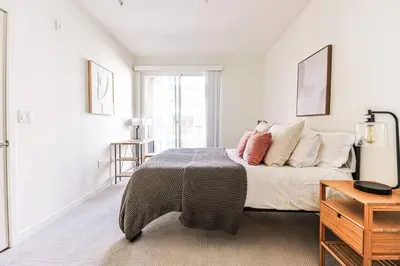 a bedroom with a bed with a table and a window at Spacious 2BD 2BA with Huge Balcony, Near Venice Beach & Fun! in Marina del Rey