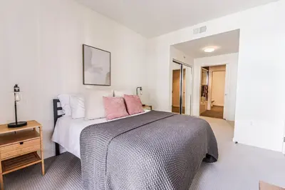 a bedroom with a large bed with pink pillows at Spacious 2BD 2BA with Huge Balcony, Near Venice Beach & Fun! in Marina del Rey