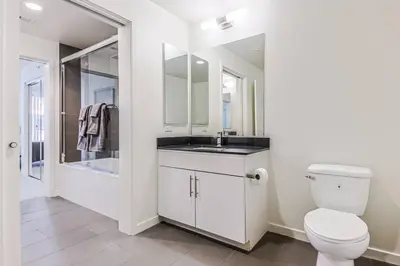 a white bathroom with a toilet and a sink at Spacious 2BD 2BA with Huge Balcony, Near Venice Beach & Fun! in Marina del Rey