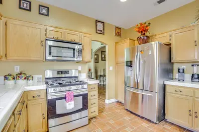 a kitchen with stainless steel appliances and wooden cabinets at Family-Friendly Home with Fenced Yard in Victorville in Victorville