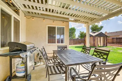 a patio with a table and chairs and a grill at Family-Friendly Home with Fenced Yard in Victorville in Victorville