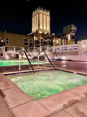 a pool of green water in a city at night at Iconic Heart of DTLA Loft with Rooftop Pool Jacuzzi Gym in Los Angeles