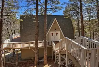 a home with a large deck and a house at Whispering Pines A-Frame, Pool Table, 2 Patios! in Lake Arrowhead