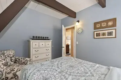 a bedroom with a bed and a dresser in it at Whispering Pines A-Frame, Pool Table, 2 Patios! in Lake Arrowhead