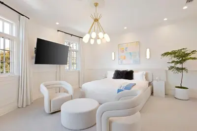 a white bedroom with a bed and a tv at Chateau Beverly Hills by Stay Awhile Villas in Los Angeles