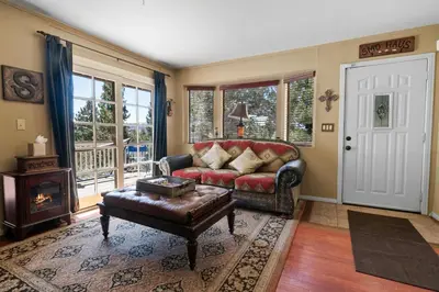 a living room with a leather couch and a table at Smo Haus- Located in the quiet area of Big Bear City, with mountain views. in Big Bear City