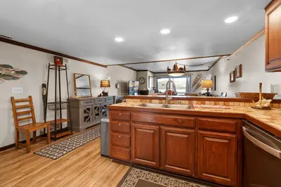 a large kitchen with wooden cabinets and a sink at Shores Lakefront Condo - Walk to Village, Lake Views, Deck with BBQ in Big Bear Lake