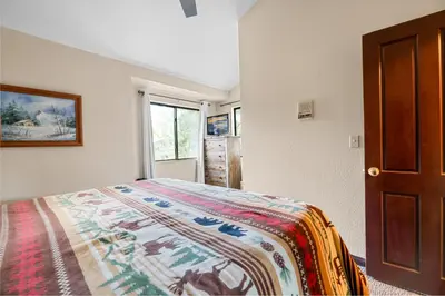 a bedroom with a bed with a blanket on it at Shores Lakefront Condo - Walk to Village, Lake Views, Deck with BBQ in Big Bear Lake