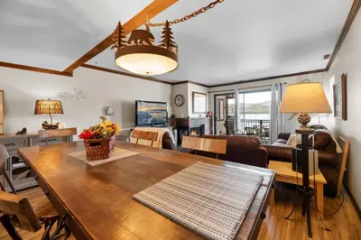 a dining room and living room with a table at Shores Lakefront Condo - Walk to Village, Lake Views, Deck with BBQ in Big Bear Lake
