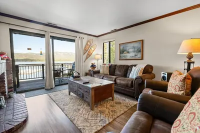 a living room with a couch and a table at Shores Lakefront Condo - Walk to Village, Lake Views, Deck with BBQ in Big Bear Lake