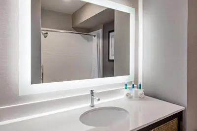 a bathroom with a sink and a mirror at Holiday Inn Express & Suites Anaheim Resort Area by IHG in Anaheim