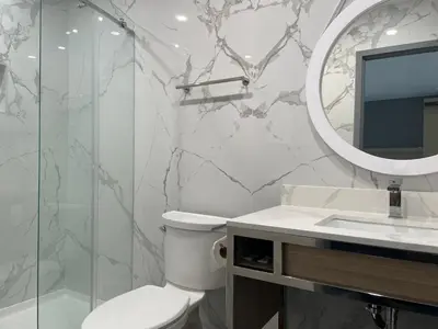 a bathroom with a toilet and a sink and a mirror at Bronco Motel South Central in Los Angeles
