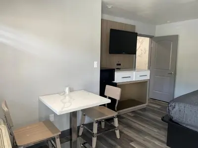 a small room with a desk and a bed at Bronco Motel South Central in Los Angeles