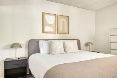 a bedroom with a bed with white sheets and pillows at Blueground N Hollywood Gym Pool nr shops LAX-515 in Los Angeles