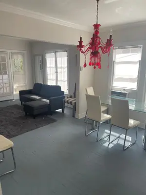 a living room with a blue couch and a glass table at Hancock weho in Los Angeles