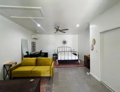a living room with a yellow couch and a bed at Great Private Studio in Noho in Los Angeles