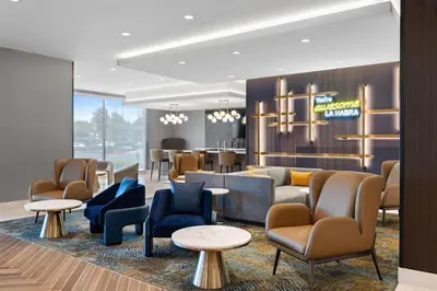 a lobby with couches and chairs and tables at La Quinta Inn & Suites by Wyndham La Habra in La Habra