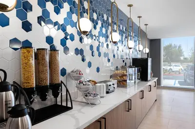 a kitchen with blue and white tiles on the wall at La Quinta Inn & Suites by Wyndham La Habra in La Habra