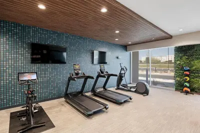 a gym with three exercise bikes and a tv at La Quinta Inn & Suites by Wyndham La Habra in La Habra