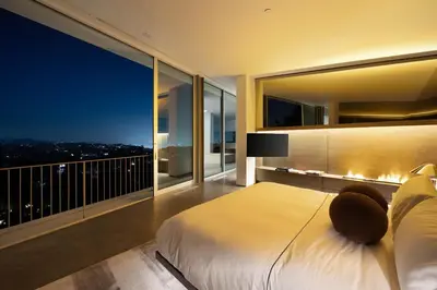a bedroom with a large white bed and a balcony at Eterne by Stay Awhile Villas in Los Angeles