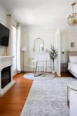 a living room with a table and a fireplace at Chambre de Bonne in Downtown Long Beach in Long Beach