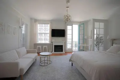 a living room with a large bed and a couch at Chambre de Bonne in Downtown Long Beach in Long Beach