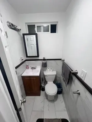 a white bathroom with a toilet and a sink at Cozy Room In Downey in Downey
