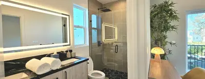 a bathroom with a sink and a shower with a mirror at Southwest Stay in Los Angeles