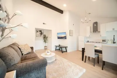 a living room and kitchen with a couch and a table at 2 TVs - Vaulted Ceiling - Private Kitchen & Entrance in Walnut