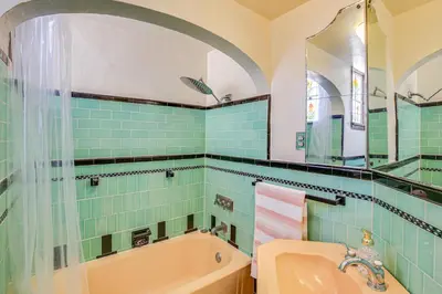 a bathroom with a tub and a sink at 1 Mi to Ocean! Home with Rooftop Deck in Long Beach in Long Beach