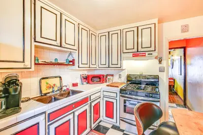 a kitchen with white cabinets and a stove top oven at 1 Mi to Ocean! Home with Rooftop Deck in Long Beach in Long Beach
