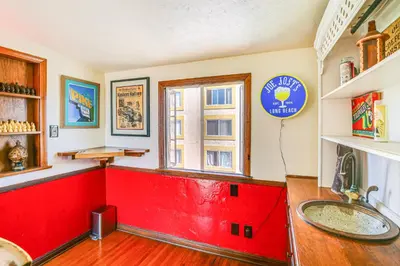 a kitchen with a red counter and a red sink at 1 Mi to Ocean! Home with Rooftop Deck in Long Beach in Long Beach