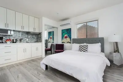 a white bedroom with a bed and a kitchen at Sunny Studio in the Heart of Venice Beach - #5 in Los Angeles