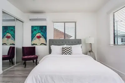 a white bedroom with a large bed and two chairs at Sunny Studio in the Heart of Venice Beach - #5 in Los Angeles