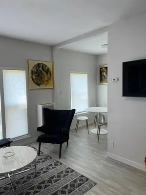 a living room with a black chair and a table at Marilyn Studio Apartment in Koreatown in Los Angeles