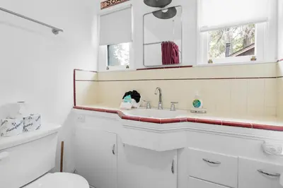 a white bathroom with a sink and a toilet at Mountain Cottage - Hot Tub! Walk to Lake and National Forest Hiking Trails in Big Bear Lake