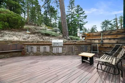 a wooden deck with a bench and a grill at Mountain Cottage - Hot Tub! Walk to Lake and National Forest Hiking Trails in Big Bear Lake