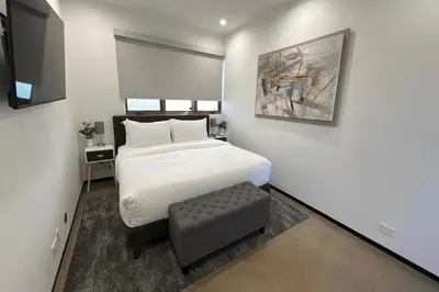 a bedroom with a large white bed and a stool at Cedar Loft Villa in Los Angeles