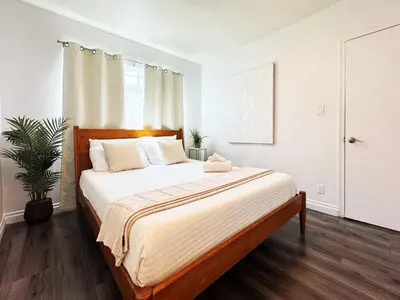 a bedroom with a large bed with white sheets at Cozy 2BR Getaway with Pool, Close to SoFi - MKMD1 in Los Angeles
