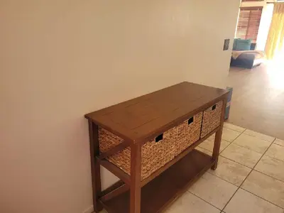 a wooden table with a wicker shelf in a room at 3BR & Loft near Palmdale Hospital- Shared Hm in Palmdale