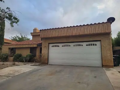 a house with a garage door in a driveway at 3BR & Loft near Palmdale Hospital- Shared Hm in Palmdale