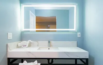 a bathroom with a white sink and a mirror at Colonial Palace Inn in Downey
